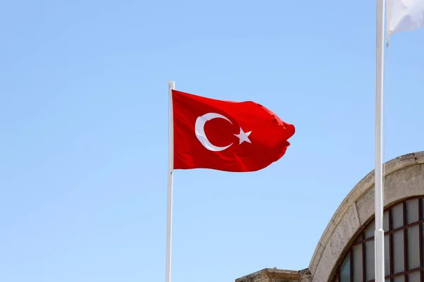きれいな青空の背景に手を振って旗竿にトルコ国旗 白い三日月と赤い背景の星 — ストック写真