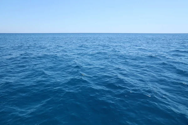 stock image The front view in the morning sky is bright blue with clear white clouds. And the ocean deep indigo in daylight. Feeling calm cool relaxing. The idea for cold background and copy space on the top