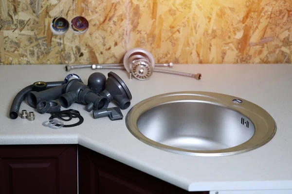 stock image Plumbers tools and water tap ready for installation near sink on countertop in kitchen. Connections for the installation of the water faucet for the kitchen sink