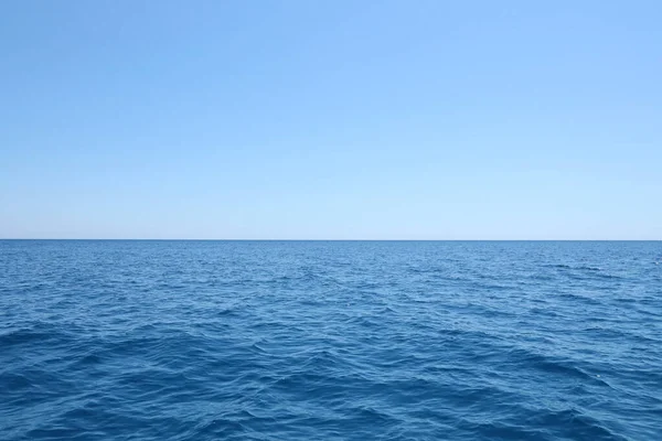 stock image The front view in the morning sky is bright blue with clear white clouds. And the ocean deep indigo in daylight. Feeling calm cool relaxing. The idea for cold background and copy space on the top