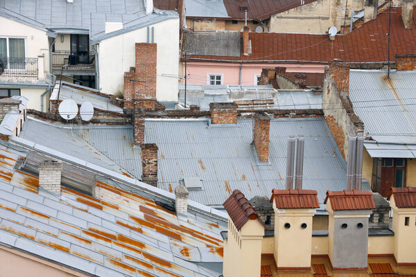 View of the roofs of historical Old city of Lviv in Ukraine. Church towers and many rusty shingled roofs in the background