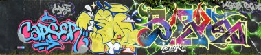 Metal duvarda parlak aerosol şeritleri olan grafiti resimlerinin renkli arka planı. Eski moda sokak sanatı sprey boya kutularından yapılmış. Çağdaş gençlik kültürü arka planı