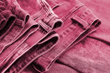 Soyunma odasında bir sürü kot pantolon var. Dolapta pantolon pantolonu var. Alım, satım, alışveriş ve modaya uygun modern kıyafetler kavramı Viva Magenta 'nın 2023 yılının renginde.