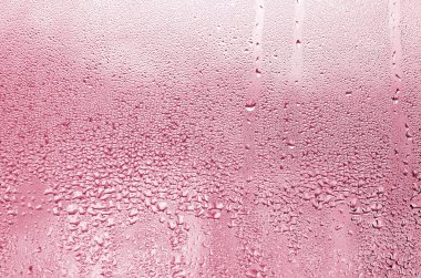 Islak, şeffaf bir arka planda, bir damla yağmurun dokusu. 2023 yılının rengi Viva Magenta renginde sarı renkli.