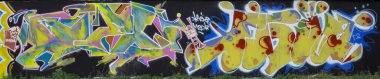 Metal duvarda parlak aerosol şeritleri olan grafiti resimlerinin renkli arka planı. Eski moda sokak sanatı sprey boya kutularından yapılmış. Çağdaş gençlik kültürü arka planı