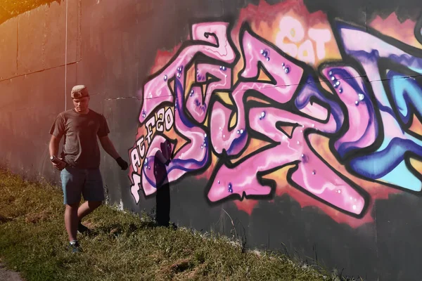 코카서스 그래피티 예술가가 파란색 분홍색의 톤으로 거리의 그림을 그리고 있습니다 — 스톡 사진