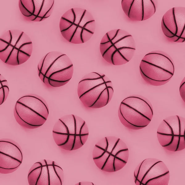 Many small orange balls for basketball sport game lies on texture background of fashion pastel orange color paper in minimal concept. Image toned in Viva Magenta, color of the 2023 year