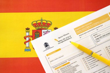 KYIV, UKRAINE - 4 Mayıs 2022 Modelo İkamet dışı vergi mükelleflerinin kurumsal gelir vergisi için 200 İspanyol vergi formu İspanya bayrağında muhasebeci masasına yakın duruyor