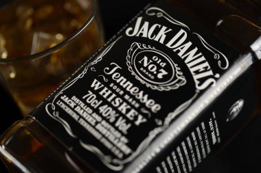 KYIV, UKRAINE - 4 Mayıs 2022 Jack Daniels orjinal alkol şişesi ahşap masa üzerinde arka planda siyah kumaş. Elit alkol üretimi