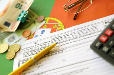 KYIV, UKRAINE - MAY 4, 2022 Portugal tax form Mod 21 RFI Double Taxation Relief on portugese official flag close up