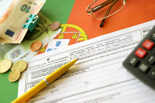 KYIV, UKRAINE - MAY 4, 2022 Portugal tax form Mod 21 RFI Double Taxation Relief on portugese official flag close up