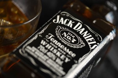 KYIV, UKRAINE - 4 Mayıs 2022 Jack Daniels orjinal alkol şişesi ahşap masa üzerinde arka planda siyah kumaş. Elit alkol üretimi