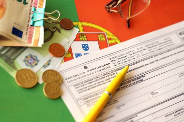 KYIV, UKRAINE - MAY 4, 2022 Portugal tax form Mod 21 RFI Double Taxation Relief on portugese official flag close up