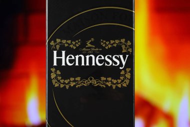 KYIV, UKRAINE - 4 Mayıs 2022 Hennessy Çok Özel alkol şişesi ahşap masada arka planda kırmızı şömine. Elit alkol üretimi