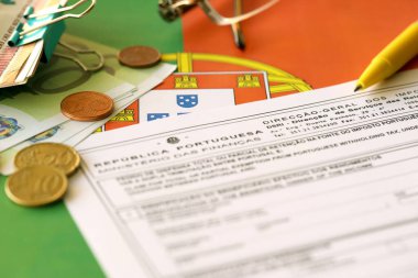 KYIV, UKRAINE - MAY 4, 2022 Portugal tax form Mod 21 RFI Double Taxation Relief on portugese official flag close up