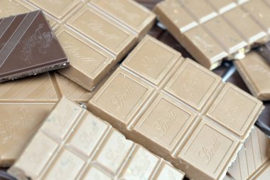 KYIV, UKRAINE - 4 Mayıs 2022 Lindt İsviçre marka lüks çikolata kahverengi tabletler ve kabartmalı orijinal şirket logosu.