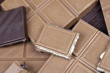 KYIV, UKRAINE - 4 Mayıs 2022 Lindt İsviçre marka lüks çikolata kahverengi tabletler ve kabartmalı orijinal şirket logosu.