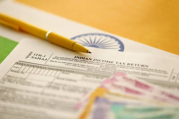 stock image KYIV, UKRAINE - MAY 4, 2022 Indian income tax return blank form with pen and indian rupees bills on indian country flag close up. Annual tax report concept