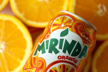 KYIV, UKRAINE - 7 Temmuz 2023: Renkli arka planda birçok taze portakal içeren Mirinda portakal suyu