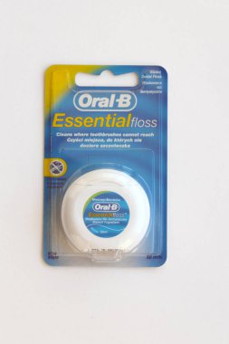 KYIV, UKRAINE - 7 Temmuz 2023: Oral-B Essentail Floss. Masadaki yuvarlak kutuda diş ipi.