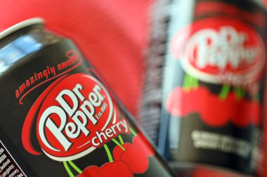 KYIV, UKRAINE - 7 Temmuz 2023: Kırmızı kumaş arka planda Dr Pepper vişne suyu kutusu