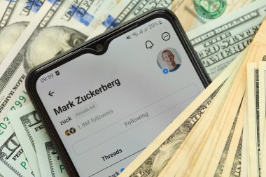 KYIV, UKRAINE - 7 Temmuz 2023: Samsung akıllı telefonu ve masadaki birçok dolarlık banknotları gösteren Meta uygulaması