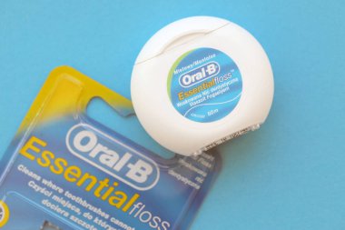 KYIV, UKRAINE - 7 Temmuz 2023: Oral-B Essentail Floss. Masadaki yuvarlak kutuda diş ipi.