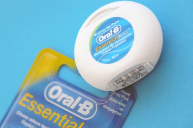 KYIV, UKRAINE - 7 Temmuz 2023: Oral-B Essentail Floss. Masadaki yuvarlak kutuda diş ipi.