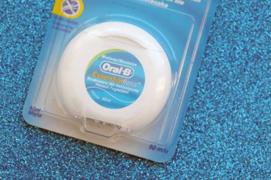 KYIV, UKRAINE - 7 Temmuz 2023: Oral-B Essentail Floss. Masadaki yuvarlak kutuda diş ipi.