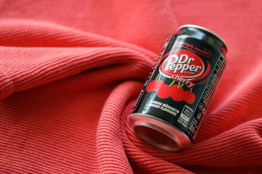 KYIV, UKRAINE - 7 Temmuz 2023: Kırmızı kumaş arka planda Dr Pepper vişne suyu kutusu