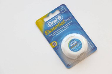 KYIV, UKRAINE - 7 Temmuz 2023: Oral-B Essentail Floss. Masadaki yuvarlak kutuda diş ipi.