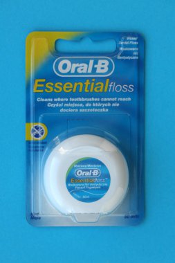 KYIV, UKRAINE - 7 Temmuz 2023: Oral-B Essentail Floss. Masadaki yuvarlak kutuda diş ipi.