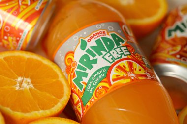 KYIV, UKRAINE - 7 Temmuz 2023: Renkli arka planda birçok taze portakal içeren Mirinda portakal suyu