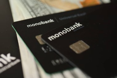 KYIV, UKRAINE - 7 Temmuz 2023: Masada parası olan Monobank siyah bankacılık kartları