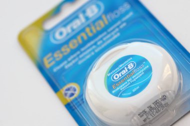 KYIV, UKRAINE - 7 Temmuz 2023: Oral-B Essentail Floss. Masadaki yuvarlak kutuda diş ipi.