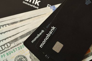 KYIV, UKRAINE - 7 Temmuz 2023: Masada parası olan Monobank siyah bankacılık kartları