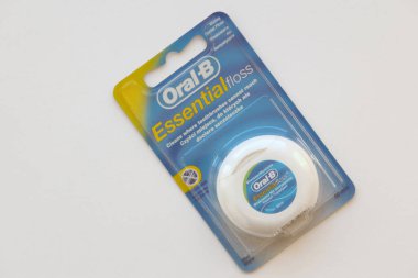 KYIV, UKRAINE - 7 Temmuz 2023: Oral-B Essentail Floss. Masadaki yuvarlak kutuda diş ipi.