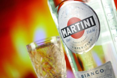 KYIV, UKRAINE - 4 Mayıs 2022 Vermouth Martini orijinal alkol şişesi ahşap masada arka planda kırmızı şömine. Elit alkol üretimi