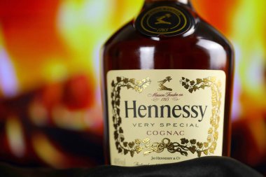 KYIV, UKRAINE - 4 Mayıs 2022 Hennessy Çok Özel alkol şişesi ahşap masada arka planda kırmızı şömine. Elit alkol üretimi