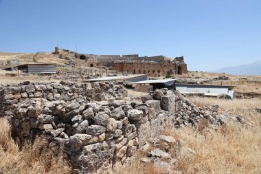ANTALYA, TURKEY - Türkiye 'nin Pamukkale kenti yakınlarındaki antik Hierapolis' in 15 Mayıs 2021 kalıntıları güneşli bir günde. Büyük blokları ve sütunları olan eski tarihi binaların parçaları.