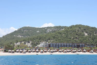 ANTALYA, TURKEY - 15 Mayıs 2021 Antalya 'nın Kiris bölgesindeki dağın eteğindeki Maxx Royal Kemer Resort oteline deniz manzarası