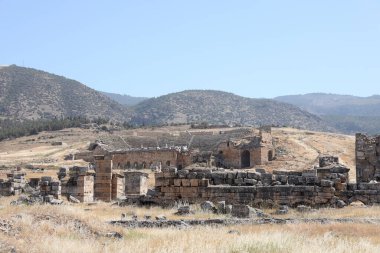 ANTALYA, TURKEY - Türkiye 'nin Pamukkale kenti yakınlarındaki antik Hierapolis' in 15 Mayıs 2021 kalıntıları güneşli bir günde. Büyük blokları ve sütunları olan eski tarihi binaların parçaları.