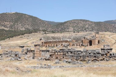 ANTALYA, TURKEY - Türkiye 'nin Pamukkale kenti yakınlarındaki antik Hierapolis' in 15 Mayıs 2021 kalıntıları güneşli bir günde. Büyük blokları ve sütunları olan eski tarihi binaların parçaları.