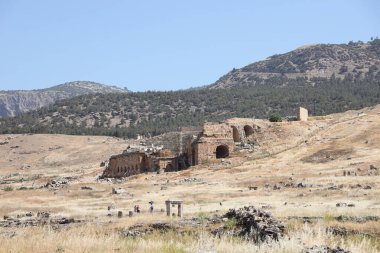 ANTALYA, TURKEY - Türkiye 'nin Pamukkale kenti yakınlarındaki antik Hierapolis' in 15 Mayıs 2021 kalıntıları güneşli bir günde. Büyük blokları ve sütunları olan eski tarihi binaların parçaları.