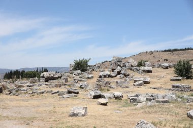 ANTALYA, TURKEY - Türkiye 'nin Pamukkale kenti yakınlarındaki antik Hierapolis' in 15 Mayıs 2021 kalıntıları güneşli bir günde. Büyük blokları ve sütunları olan eski tarihi binaların parçaları.