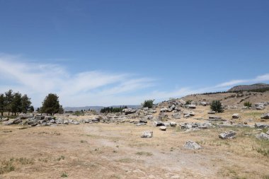 ANTALYA, TURKEY - Türkiye 'nin Pamukkale kenti yakınlarındaki antik Hierapolis' in 15 Mayıs 2021 kalıntıları güneşli bir günde. Büyük blokları ve sütunları olan eski tarihi binaların parçaları.