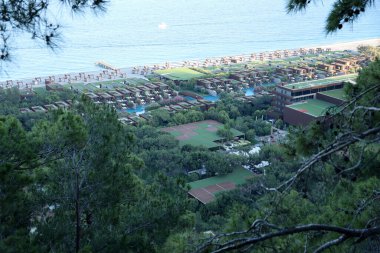 ANTALYA, TURKEY - 15 Mayıs 2021 Antalya 'nın Kiris bölgesindeki dağın eteğindeki Maxx Royal Kemer Resort oteline deniz manzarası
