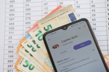 TERNOPIL, UKRAINE - 3 AĞUSTOS, 2023 Capitec uygulaması modern akıllı telefon ekranında ve çok sayıda Avro para birimi faturası