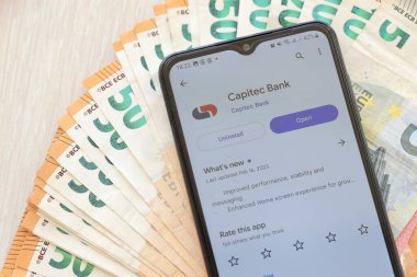 TERNOPIL, UKRAINE - 3 AĞUSTOS, 2023 Capitec uygulaması modern akıllı telefon ekranında ve çok sayıda Avro para birimi faturası