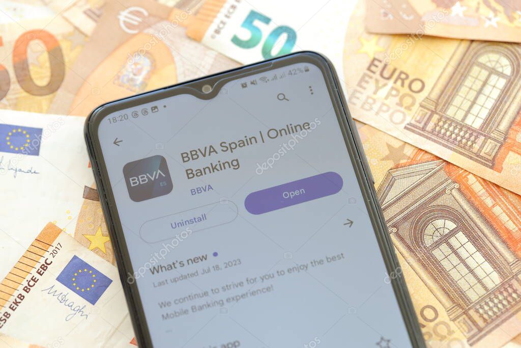 TERNOPIL, UKRAINE - AUGUST 3, 2023 BBVA Spain application on screen on modern smartphone and many bills of european euro currency